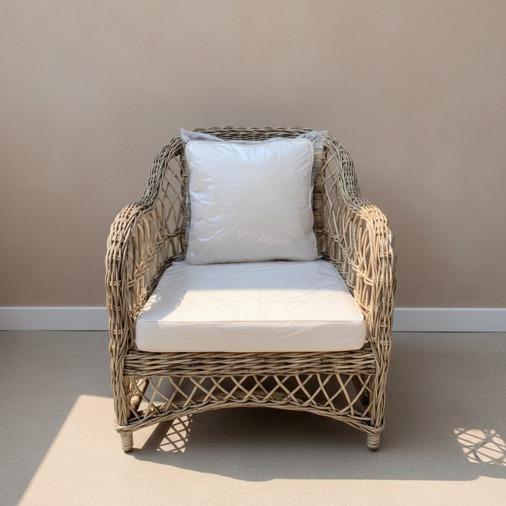 Wicker armchair with white cushions on a neutral background
